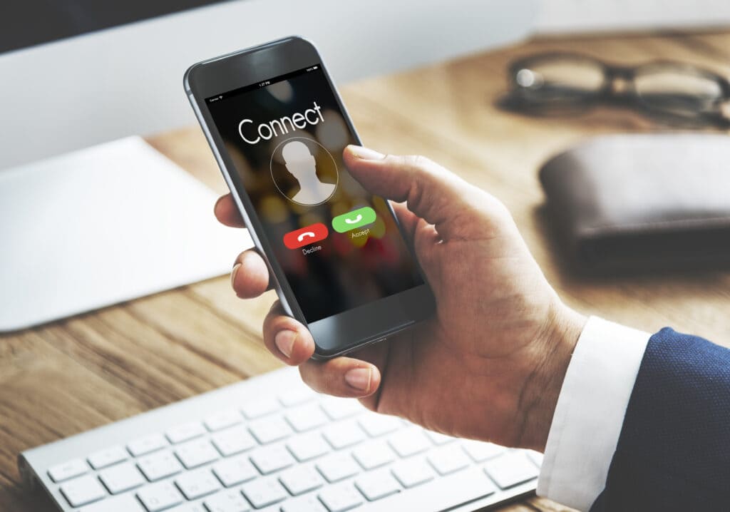 Um homem de terno utilizando o celular para redirecionar uma chamada de voz.