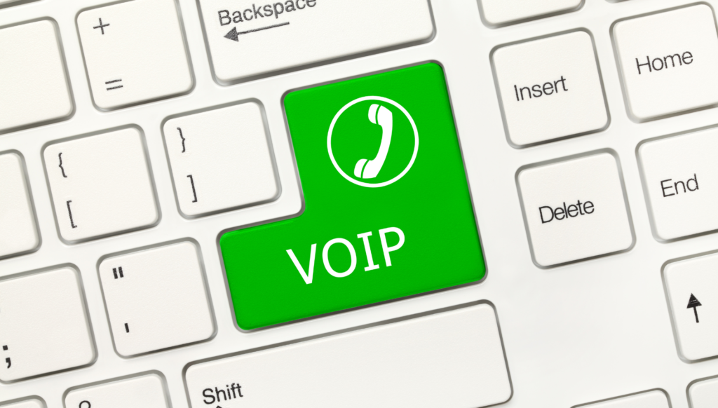 Teclado de computador com um botão na cor verde escrito "voip"