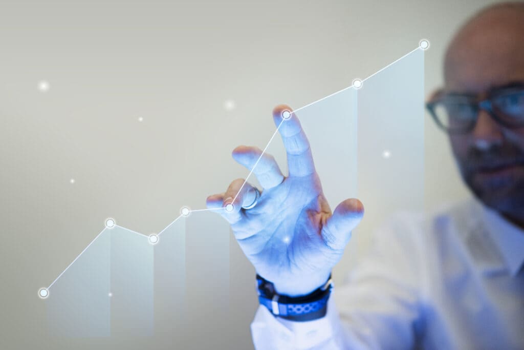 Empresário apontando os dedos para um gráfico de superação de resultados.