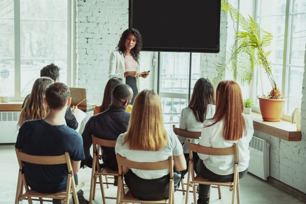 Pessoas recebendo treinamento sobre atendimento telefônico em uma sala.