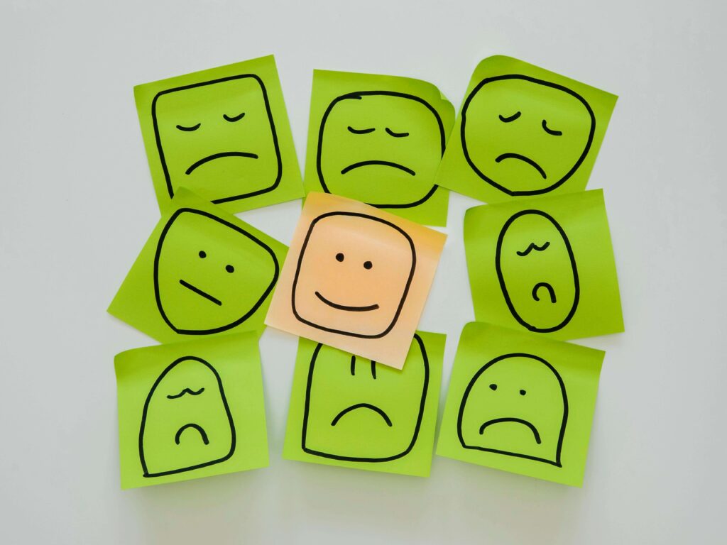 parede com vários post its com rostos felizes ou tristes.
