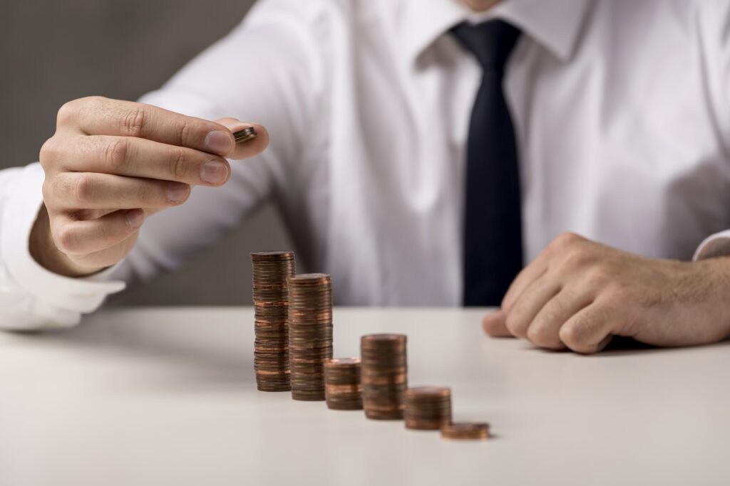 A simbologia da redução de custos retratada em uma imagem onde um empresário está contando moedas. Como se estivesse analisando a telefonia de sua empresa, visando a redução de custos com a utilização do voip.