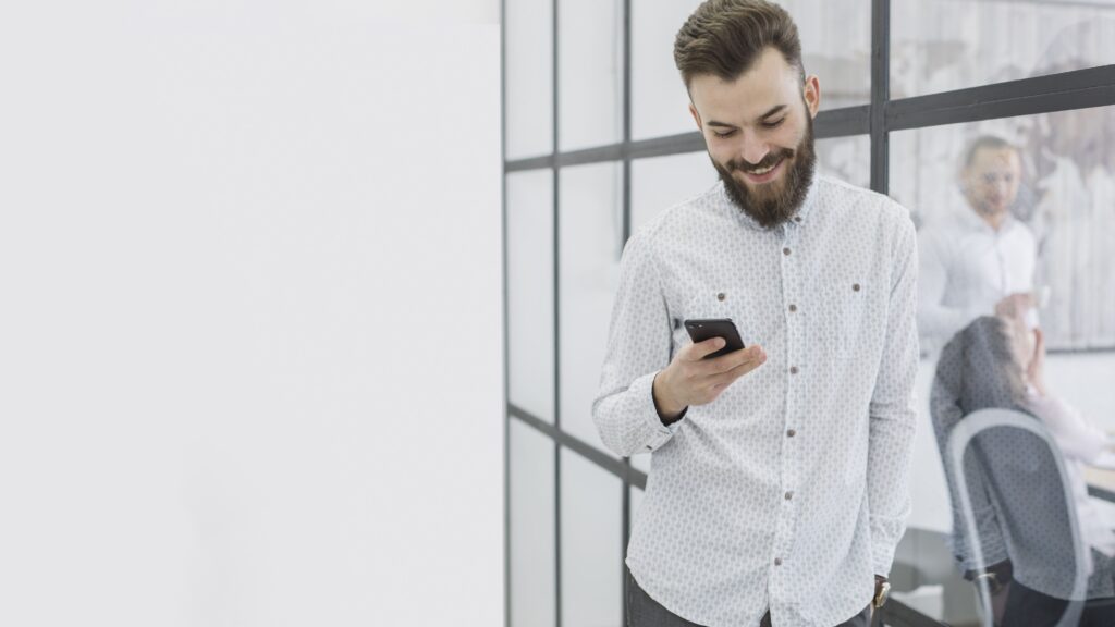 Empresário utilizando o celular para atender aos seus clientes de forma mais flexível.