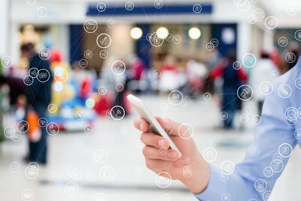 Homem com celular e vários ícones de aplicações e funcionalidades, representando a integração do pabx virtual