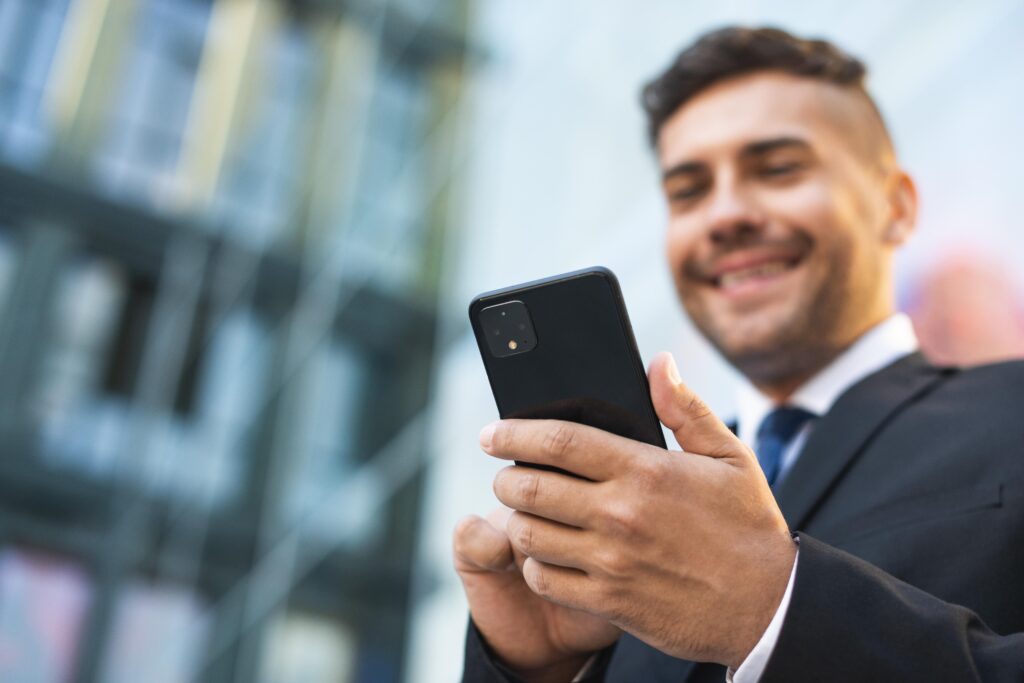 Homem de negócios utilizando o smartphone como telefone fixo pela utilidade do voip.